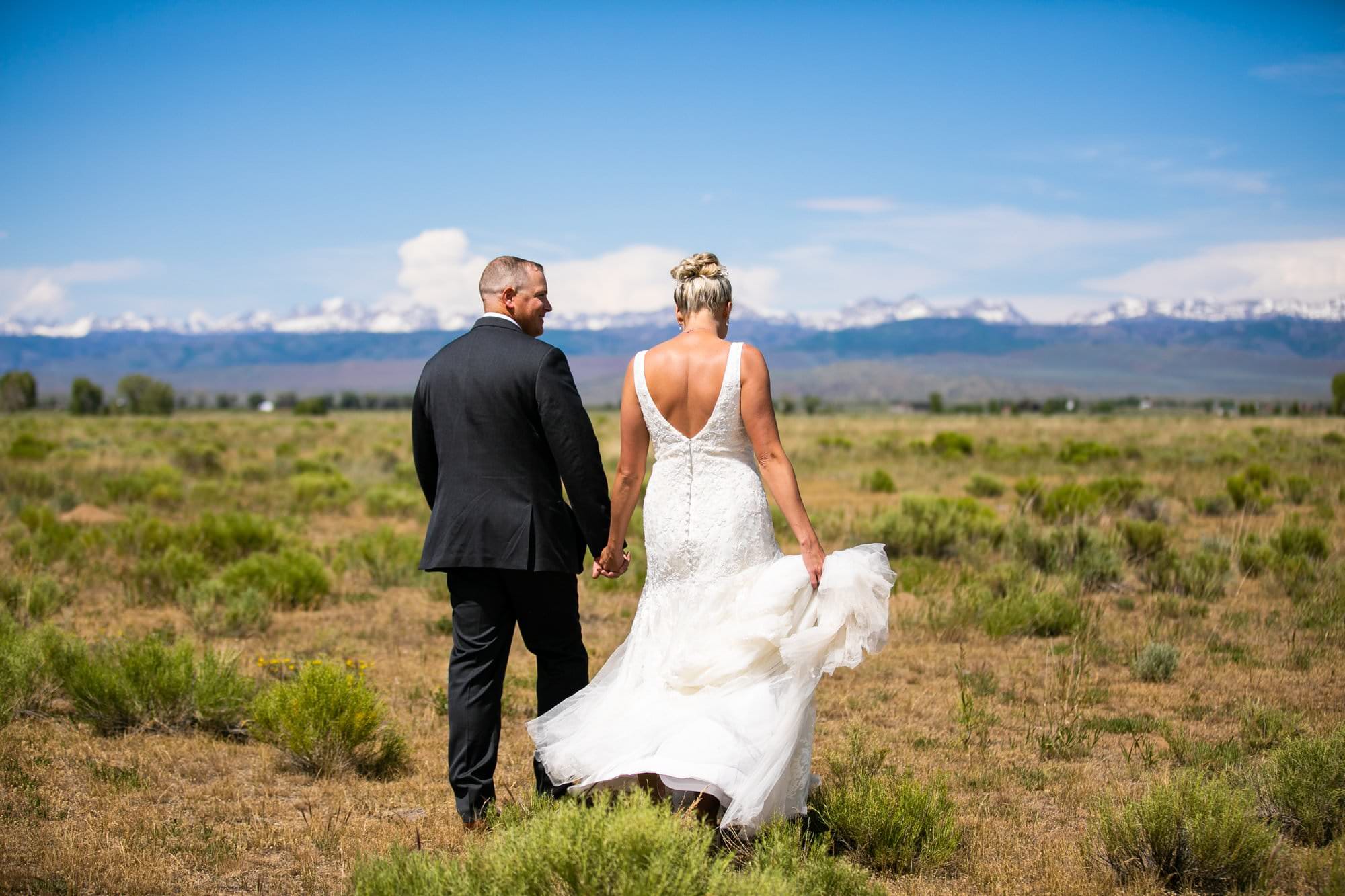 wyoming bride groom walking toward wind river mountains