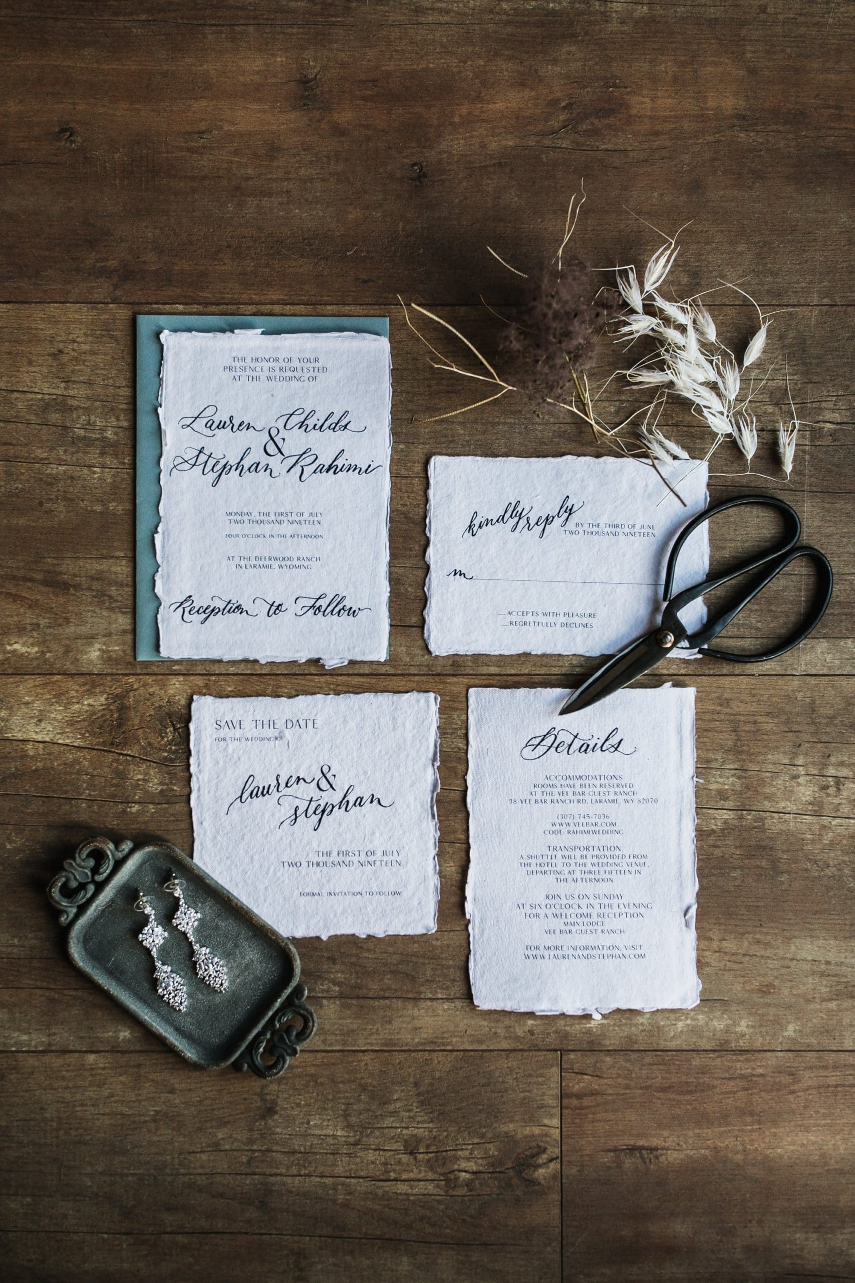 invitation suite on barn wood flat lay