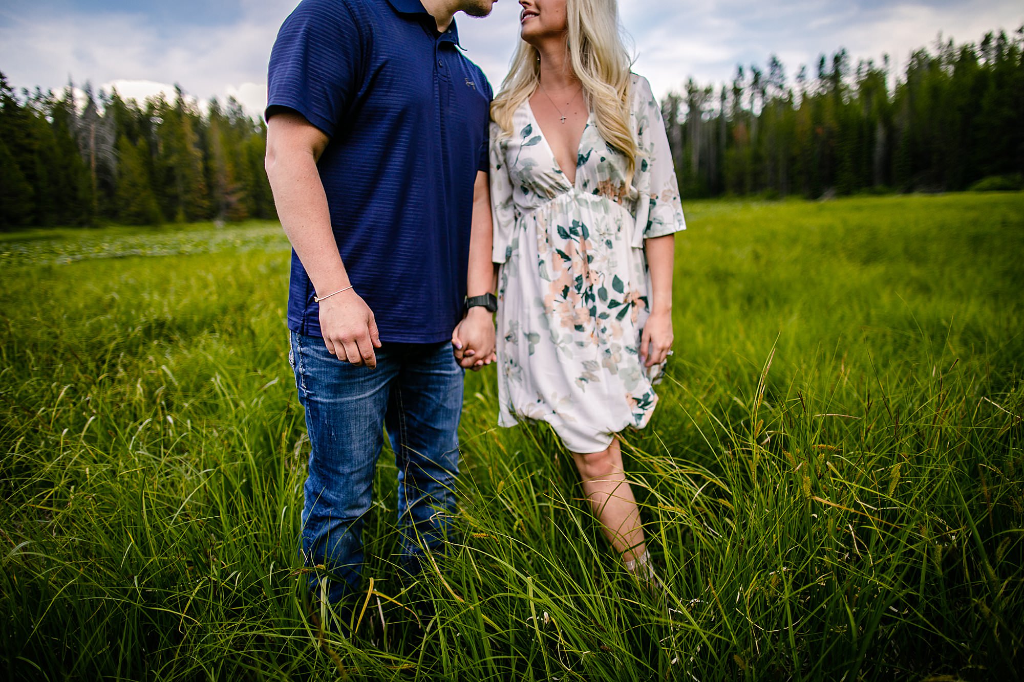 couple holding hands in grass