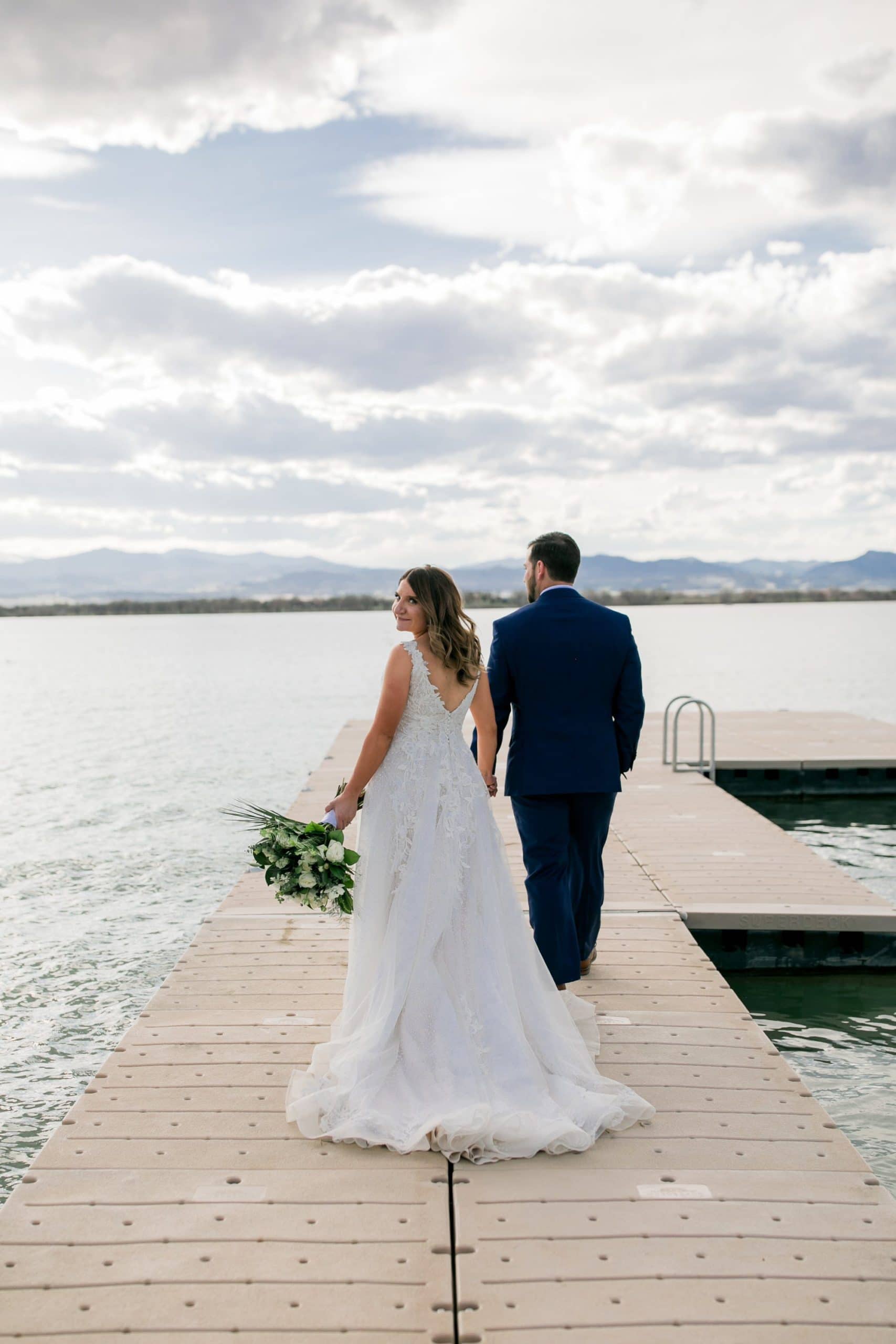 bride and groom walking toward lake during Loveland, Colorado wedding