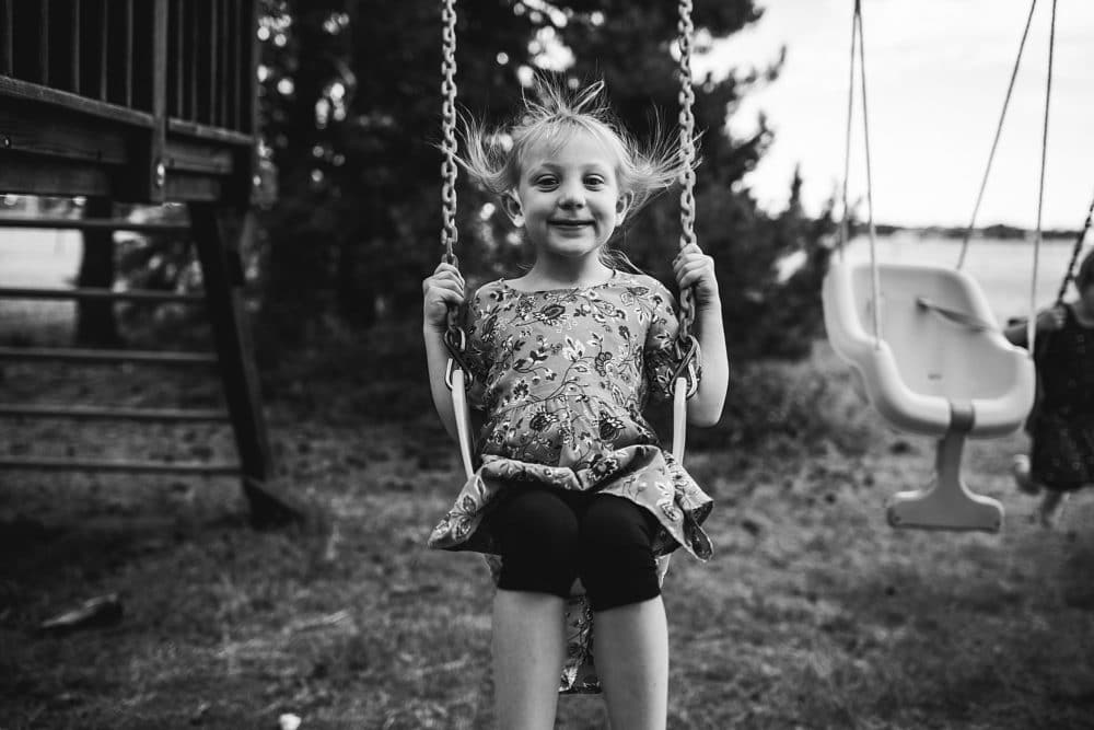 little girl on swing smiling