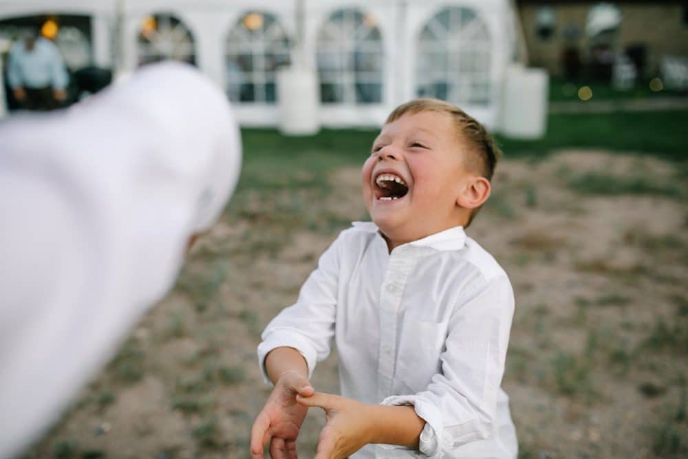 little boy laughing at wedding reception