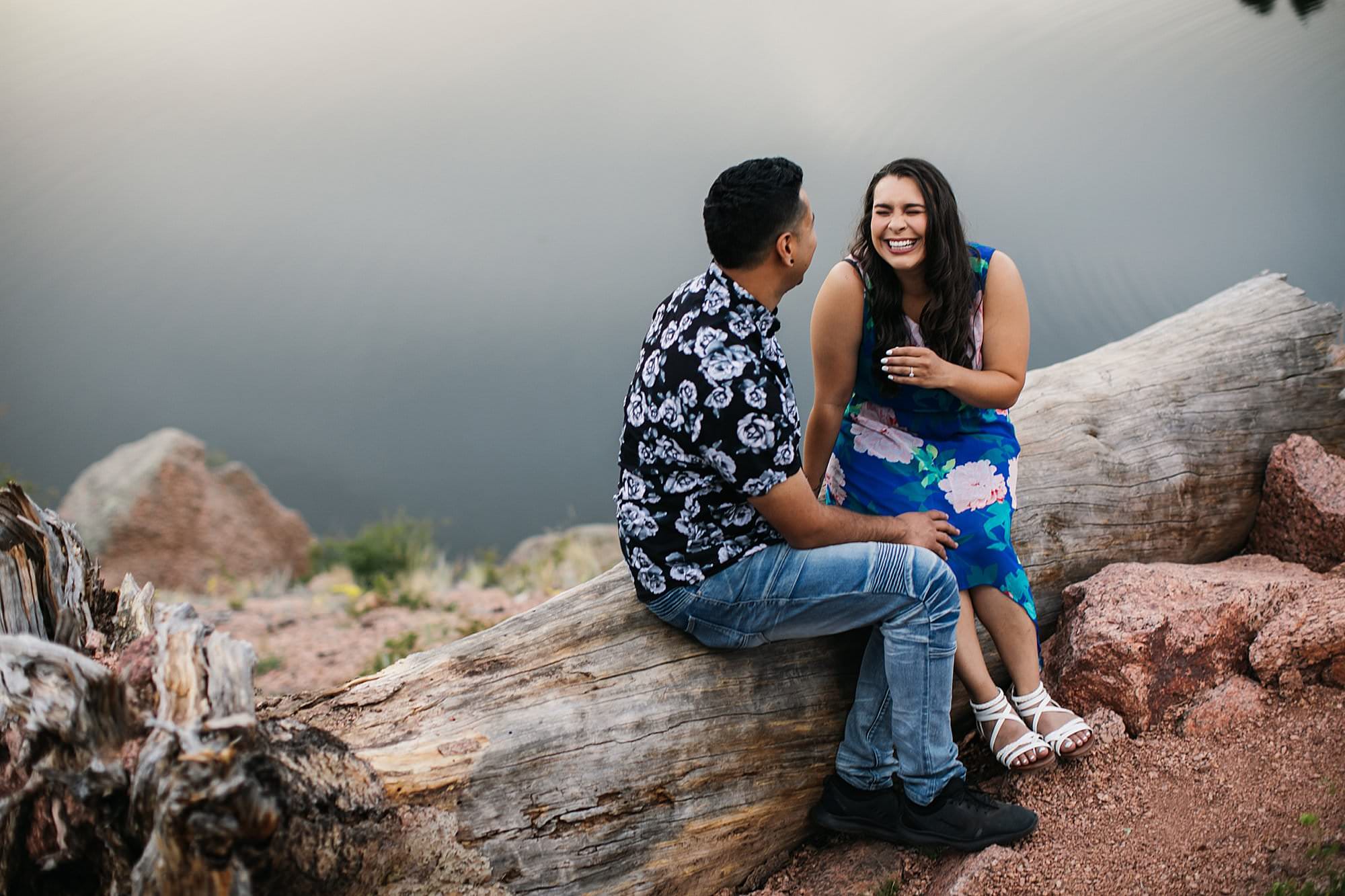 couple laughing together by water in mountains