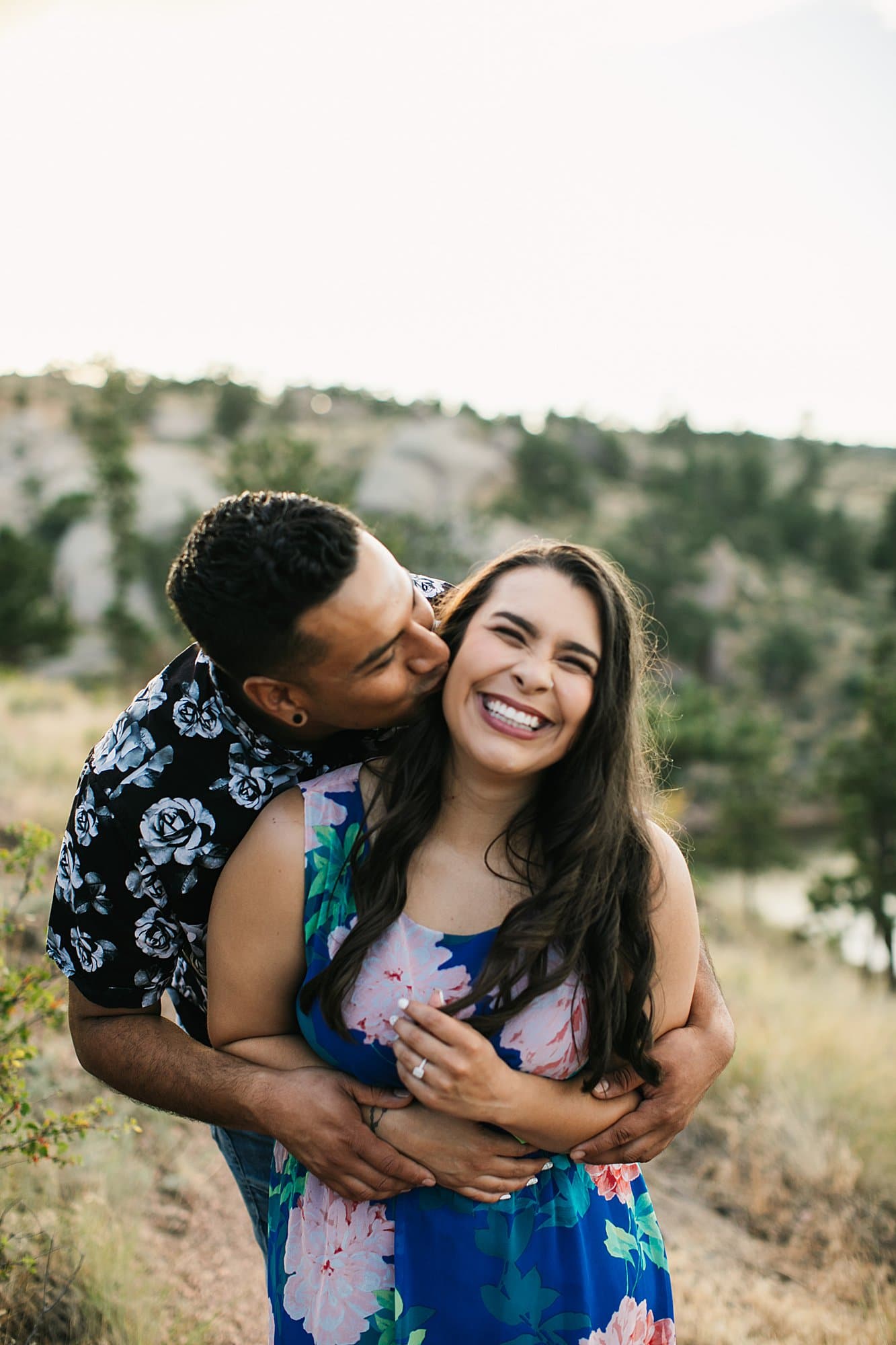 couple cuddling for engagement shoot, laughing bride